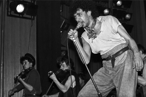 Kevin Rowland of Dexys Midnight Runners on stage in 1982 with the band's fiddle players behind him