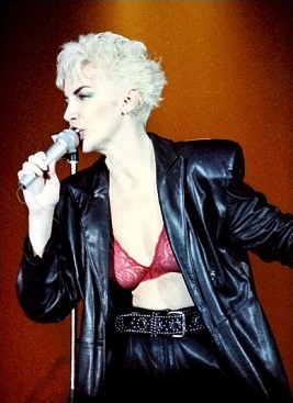 Annie Lennox performing on stage in 1986 in a leather jacket
