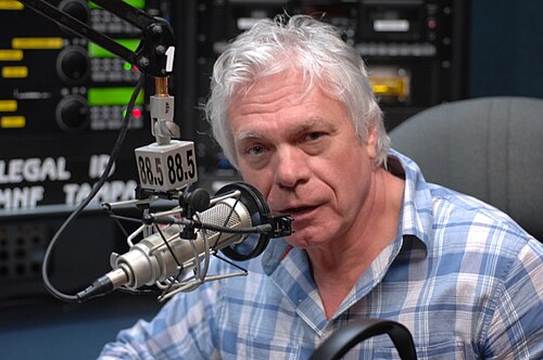 A radio DJ at a studio mixing board and microphone, the person on the other end of the request line who decided whether your song got played