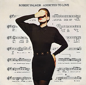 The Robert Palmer Addicted to Love single cover, a woman in a black dress over sheet music