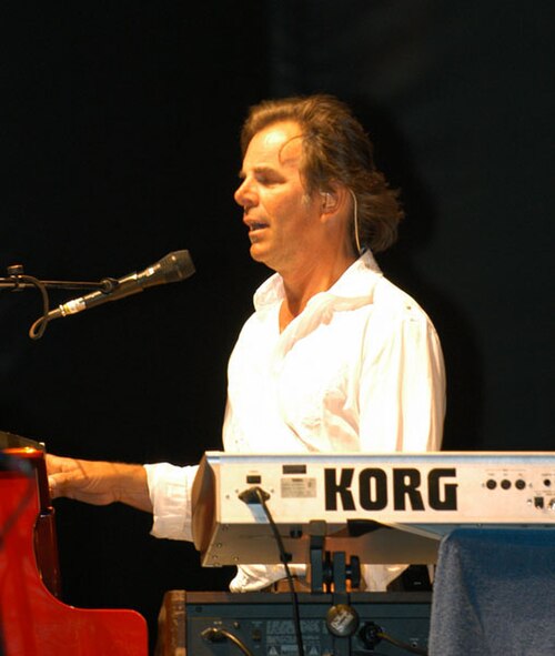 Jonathan Cain singing and playing a Korg keyboard on stage