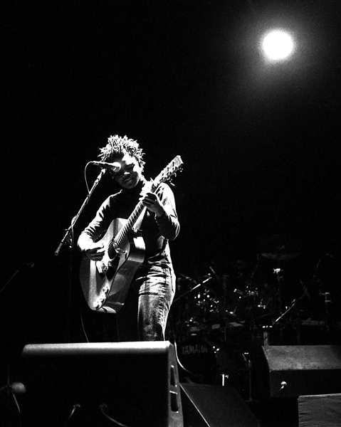 Tracy Chapman singing and playing guitar on stage in 1988