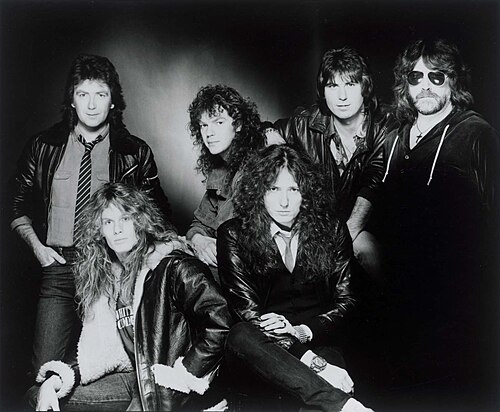 A black and white group portrait of the six members of Whitesnake in leather jackets, 1984