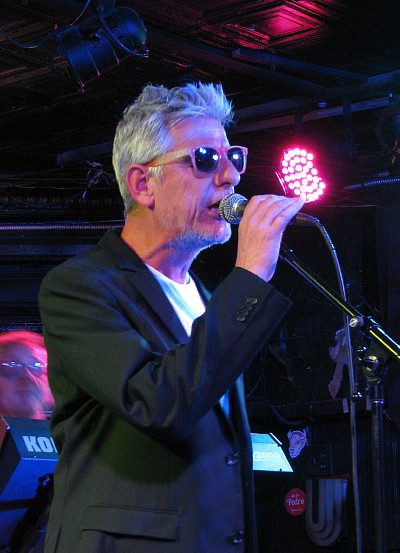Modern English singer Robbie Grey performing into a microphone on stage