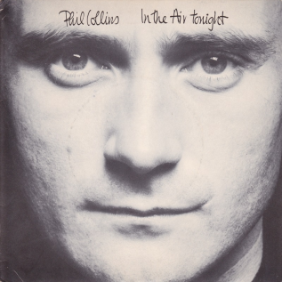 The single cover art for In the Air Tonight by Phil Collins, a close up black and white photo of his face with the title in handwriting font