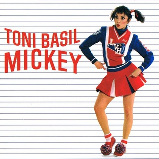The single cover art for Mickey by Toni Basil, Basil posing in a cheerleader outfit against a striped background