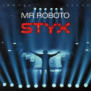 The Styx Mr. Roboto single cover, a silhouetted figure with arms outstretched under stage lights