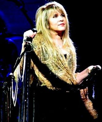 Stevie Nicks singing into a microphone on stage