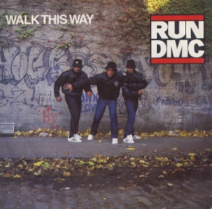 The single cover art for Walk This Way by Run-DMC, the three members walking past a graffiti wall