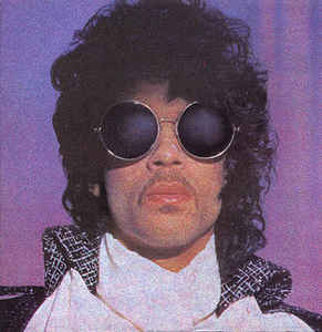 The single cover art for When Doves Cry by Prince, a close up portrait of Prince wearing round dark sunglasses