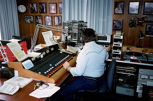 A radio station studio with console, microphone, and monitors, the control room where 80s CHR DJs kept the Top 40 rotation running