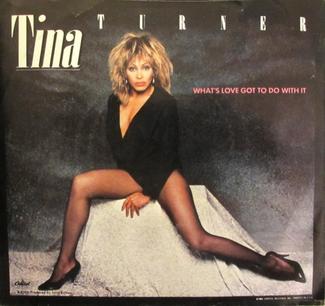 The single cover for What's Love Got to Do with It by Tina Turner, a photo of her seated on a stool in a black outfit